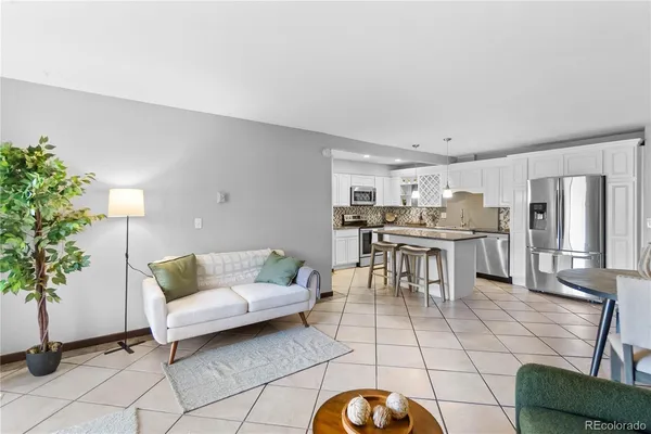 a living room with furniture and kitchen view