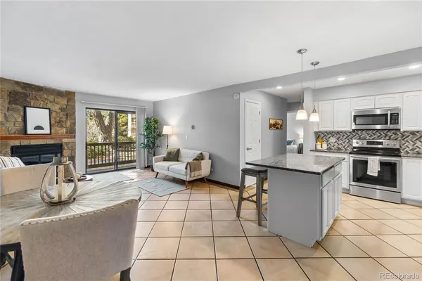 a kitchen with stainless steel appliances kitchen island granite countertop a refrigerator a stove a sink and a microwave