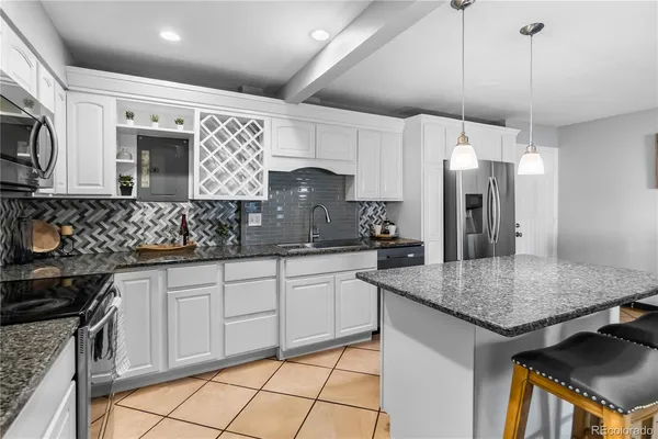 a kitchen with stainless steel appliances granite countertop a sink and a stove