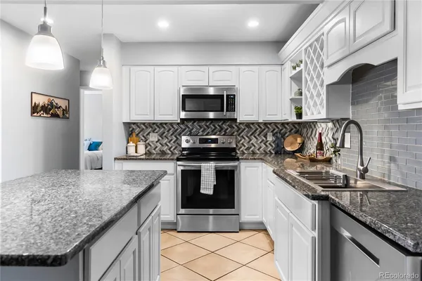 a kitchen with granite countertop a sink and a stove