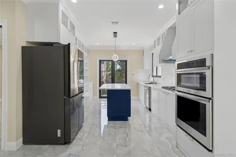 a kitchen with stainless steel appliances granite countertop a refrigerator and a stove top oven