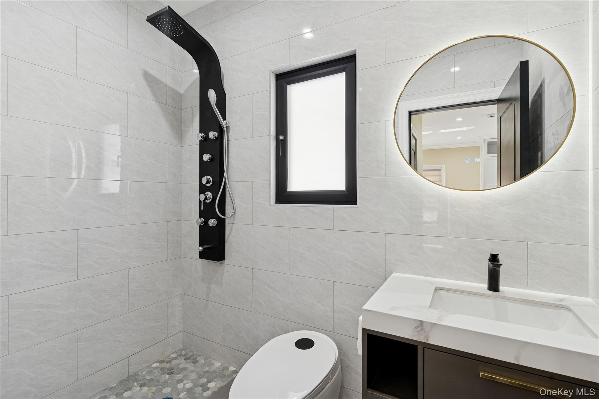 81-25 265th Street Queens, NY 11004 - Photo 21 of 44 Full bathroom featuring vanity, tile walls, smart toilet, smart mirror, shower jet