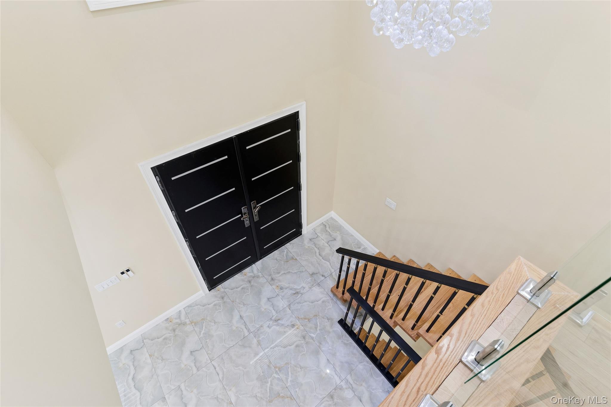 81-25 265th Street Queens, NY 11004 - Photo 23 of 44 Stairway featuring a chandelier