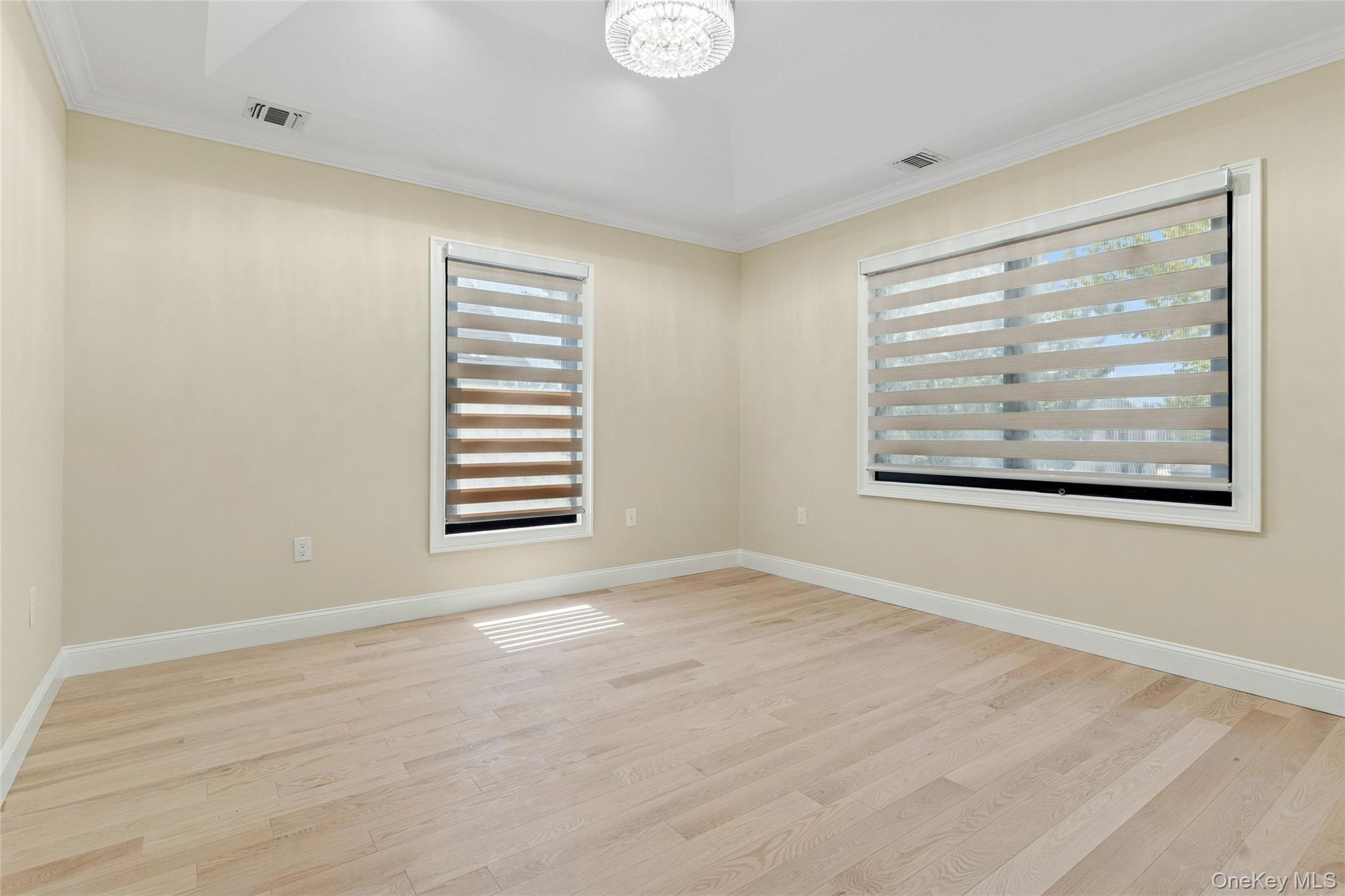 81-25 265th Street Queens, NY 11004 - Photo 24 of 44 Second Floor Bedroom 1 featuring light wood finished floors, ornamental molding, and a chandelier