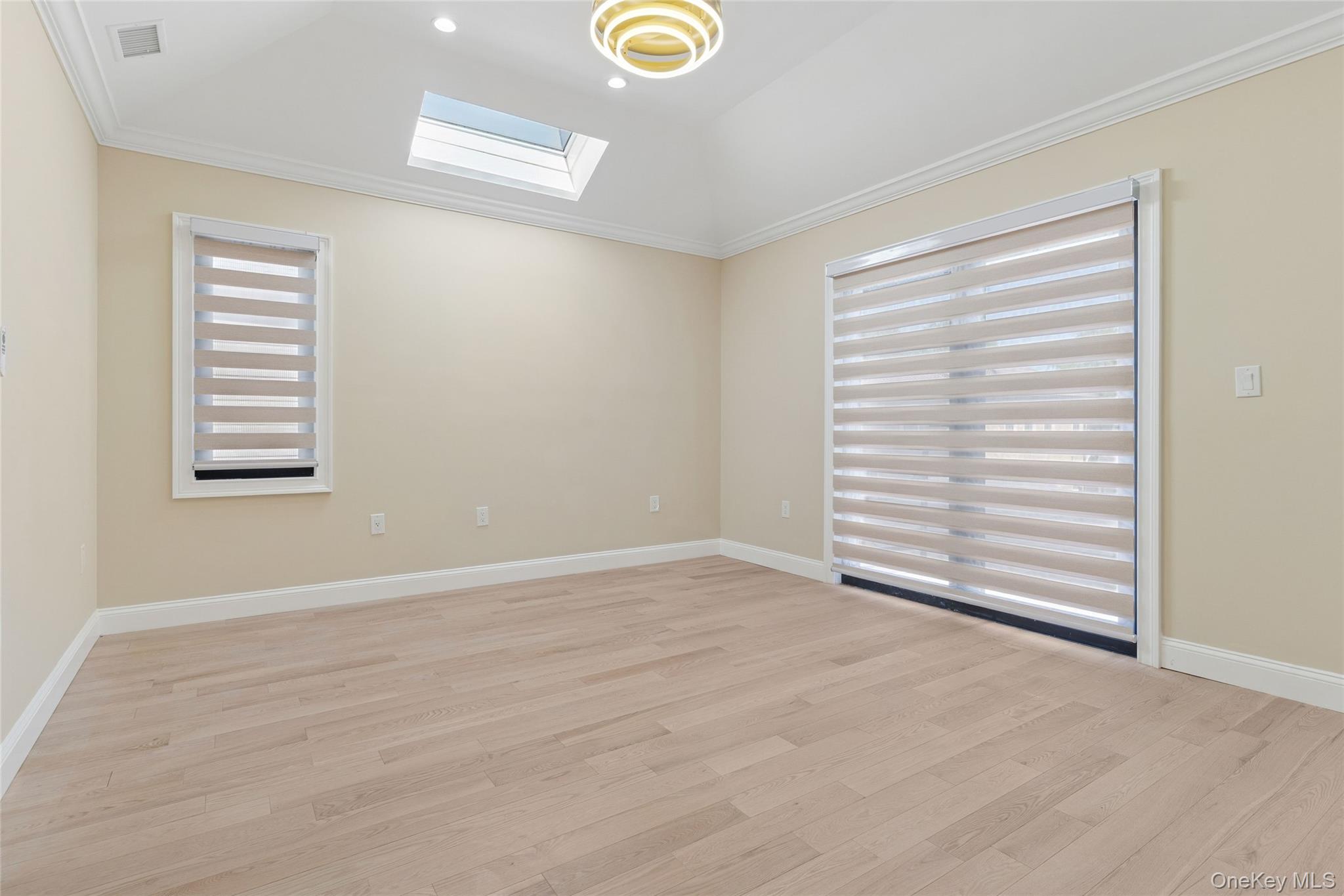 81-25 265th Street Queens, NY 11004 - Photo 28 of 44 En suite featuring crown molding, a skylight, light wood-style floors, and recessed lighting