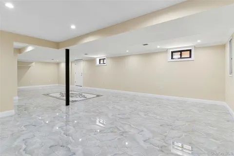 a view of an empty room and kitchen with furniture