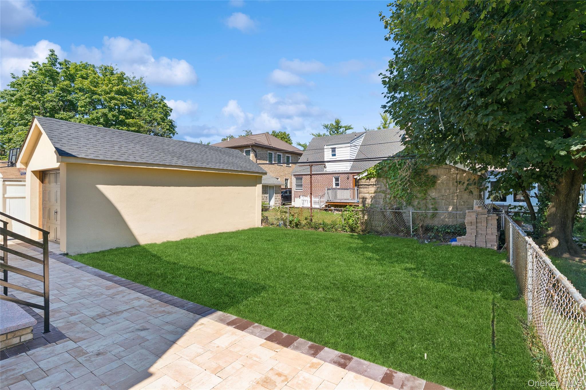 81-25 265th Street Queens, NY 11004 - Photo 9 of 44 Fenced backyard featuring an outbuilding and a patio area