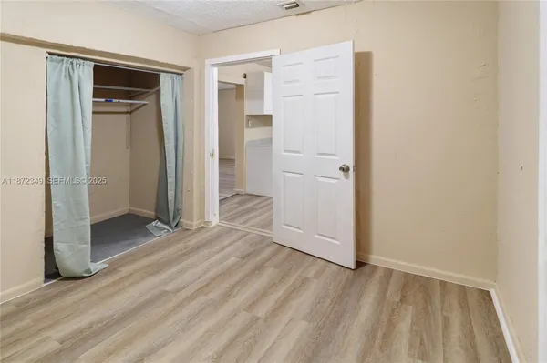 an empty room with wooden floor and closet
