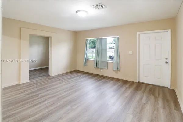 wooden floor in an empty room with a window
