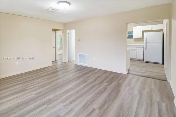 a view of empty room with wooden floor