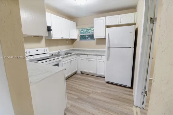 a kitchen with a sink a refrigerator a washer and dryer