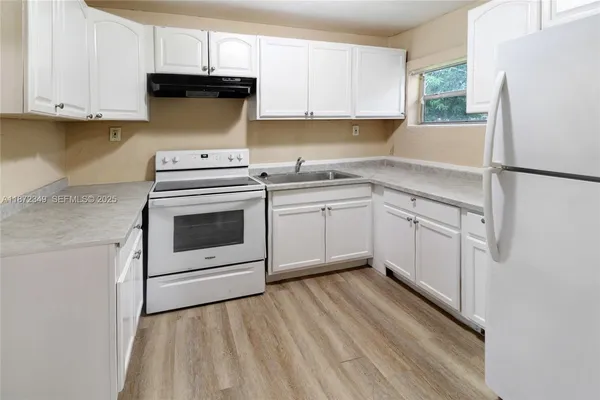 a kitchen with a white cabinets and white appliances