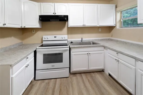 a kitchen with granite countertop white cabinets and white appliances