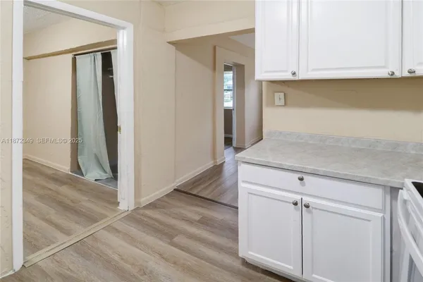 a living room with a wooden floor and cabinets