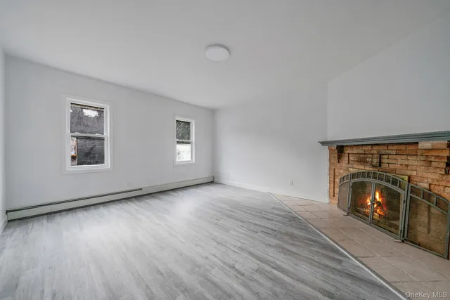 a view of a livingroom with wooden floor and a fireplace