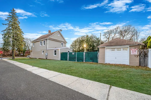 a view of a house with a yard and large tree