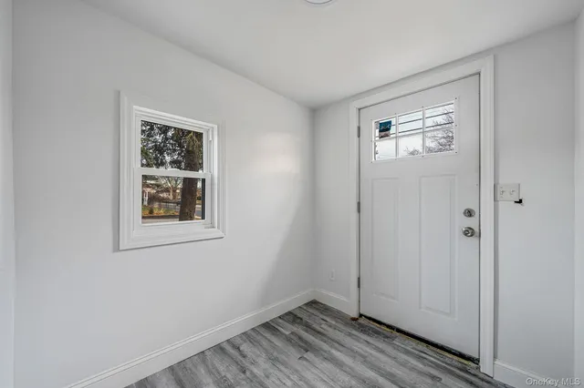 a view of an empty room with closet and a window