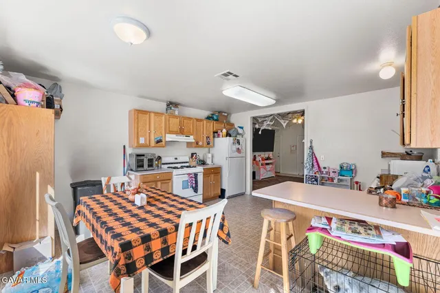 a view of a dining room with furniture and a kitchen