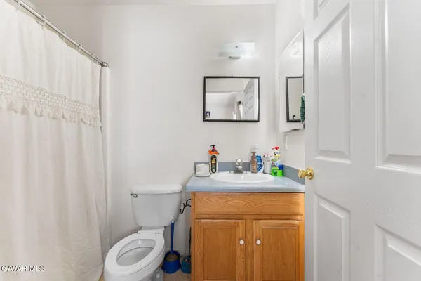 a bathroom with a sink a toilet and a mirror