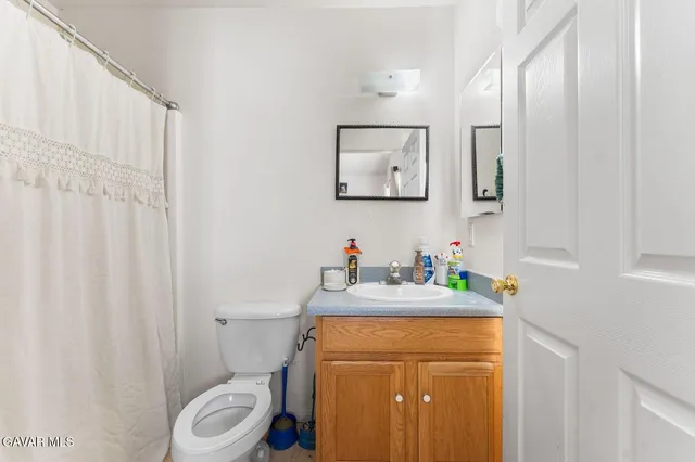 a bathroom with a sink a toilet and a mirror