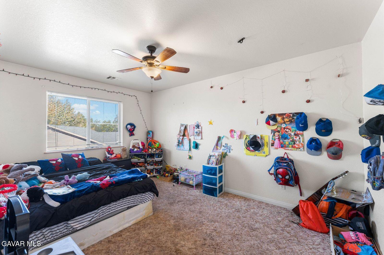 18330 Basil Drive Tehachapi, CA 93561 - Photo 29 of 47 a bedroom with furniture and a chandelier fan