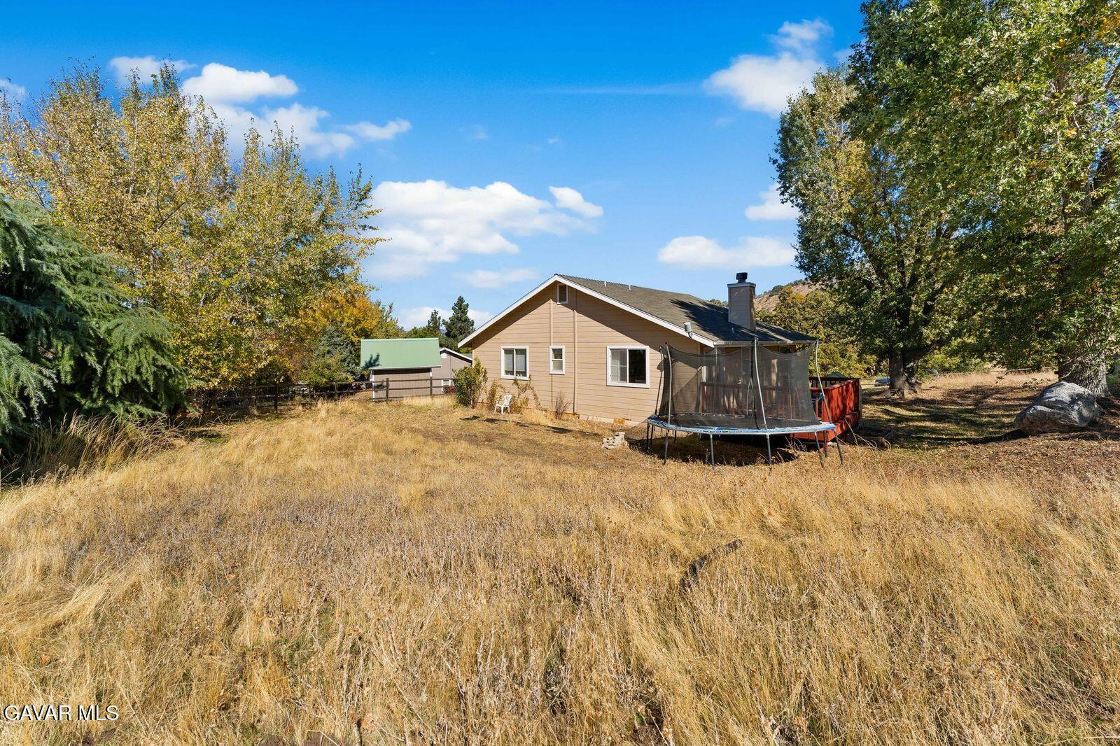 18330 Basil Drive Tehachapi, CA 93561 - Photo 33 of 47 a house view with tall trees in front of it