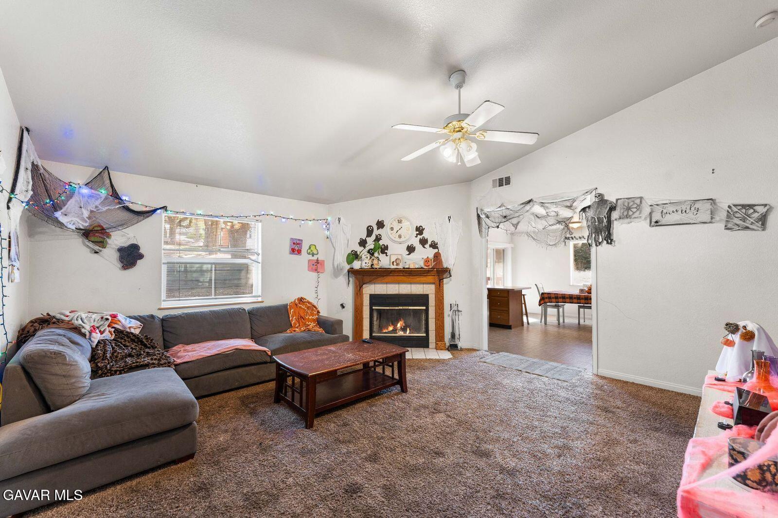 18330 Basil Drive Tehachapi, CA 93561 - Photo 9 of 47 a living room with furniture a fireplace and a chandelier