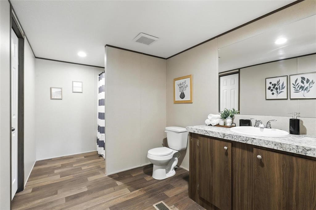 131 Kelly Court Azle, TX 76020 - Photo 15 of 22 a bathroom with a granite countertop sink a toilet and a mirror