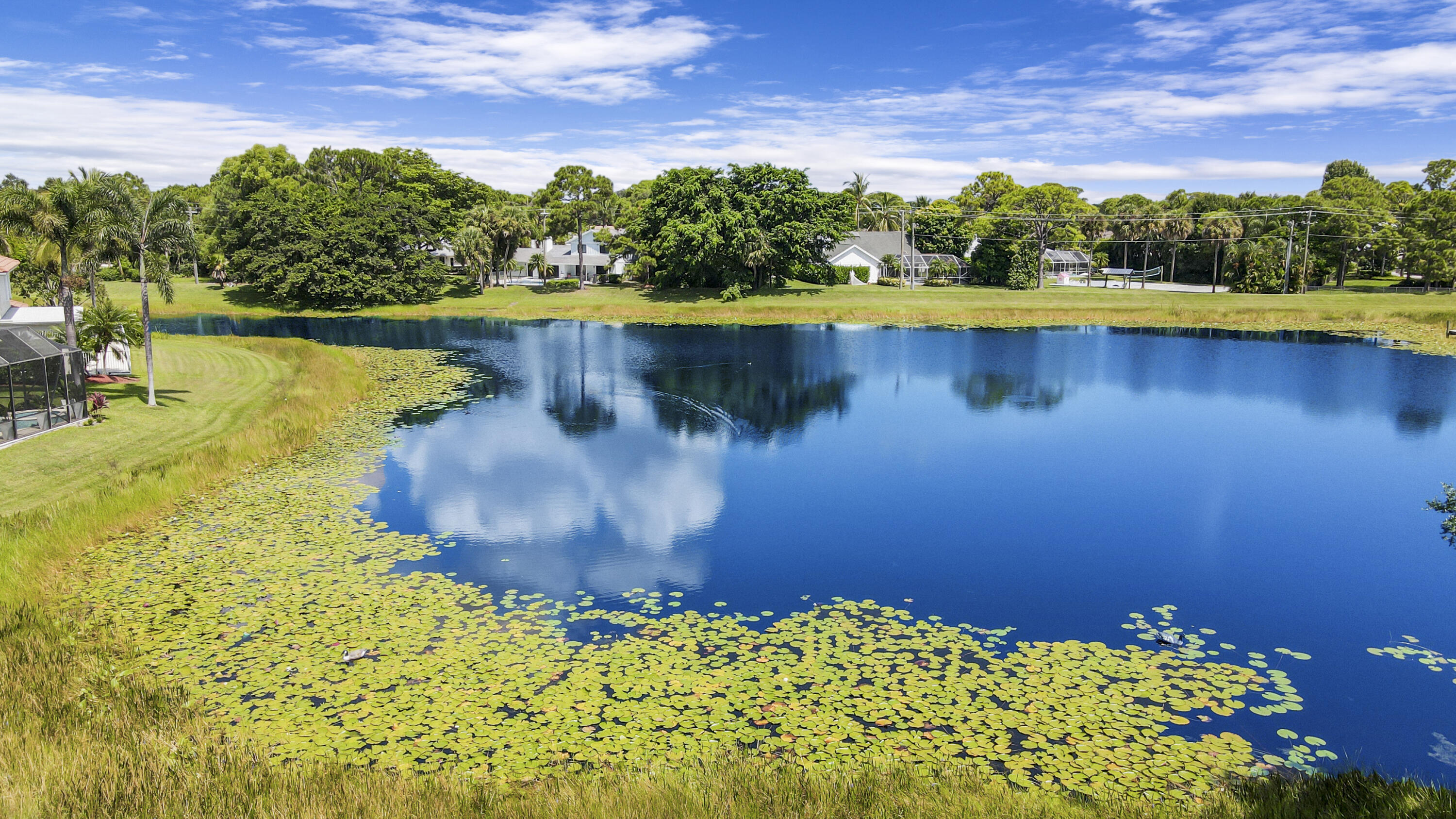 6369 Longleaf Pine Drive Jupiter, FL 33458 - Photo 4 of 53 a view of a lake with a house in the background