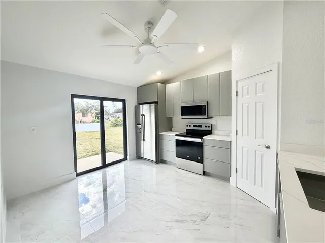 a large white kitchen with cabinets and stainless steel appliances