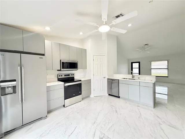 a kitchen with a refrigerator sink and stove top oven