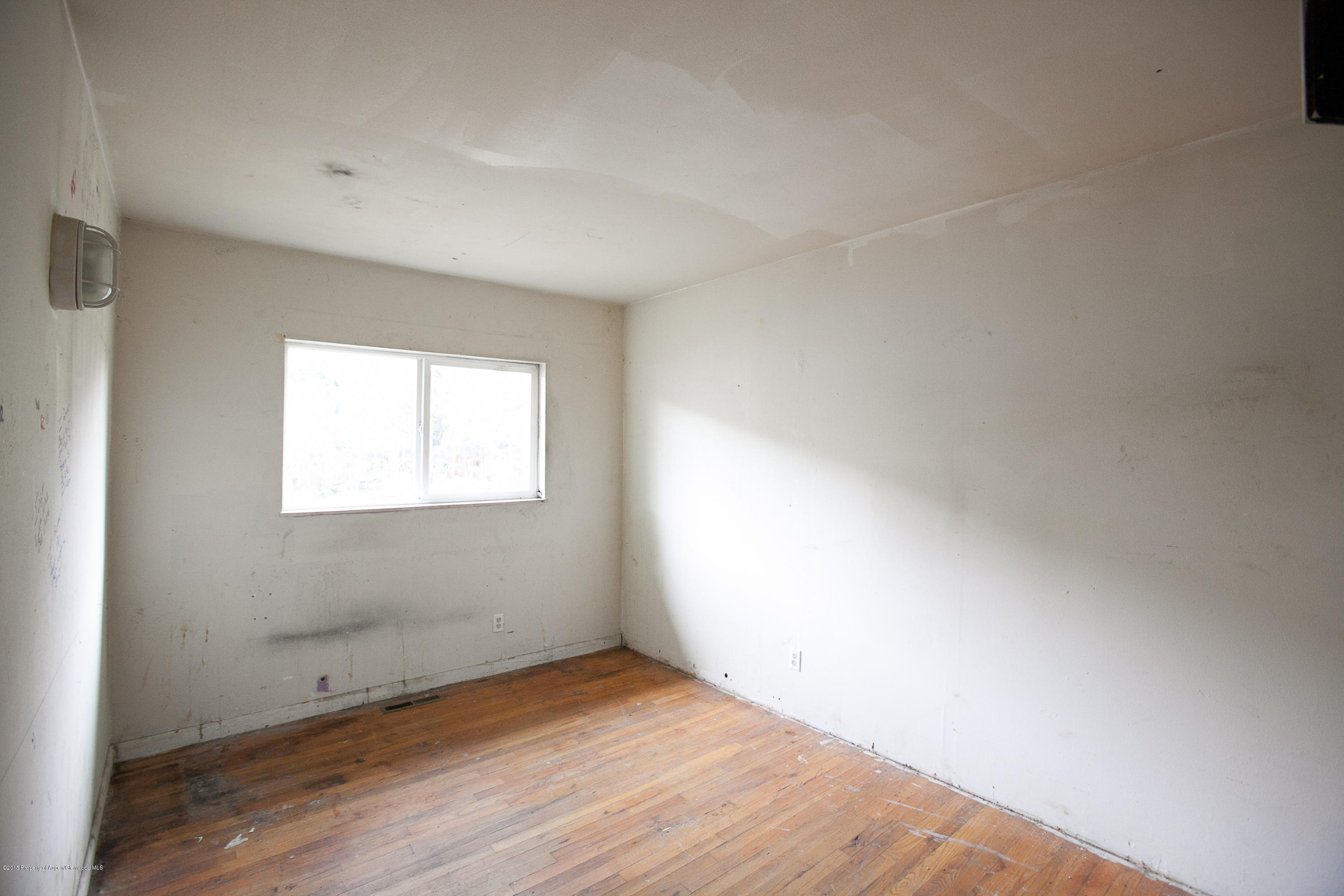 145 June Street Rifle, CO 81650 - Photo 11 of 17 an empty room with wooden floor and windows