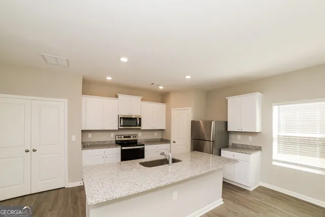 a kitchen with stainless steel appliances granite countertop a refrigerator sink and stove