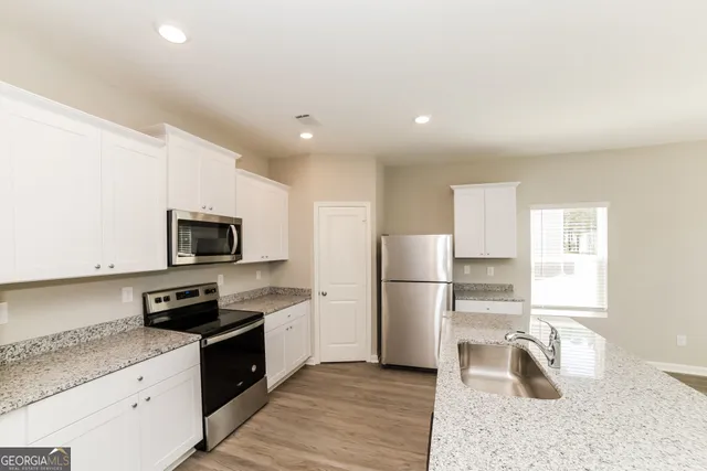 a kitchen with a refrigerator a microwave a sink and a stove