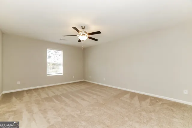 an empty room with a window and a fan