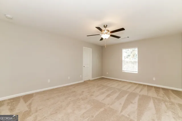 an empty room with window and ceiling fan