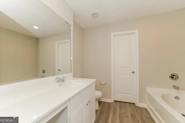 a spacious bathroom with a tub sink and mirror