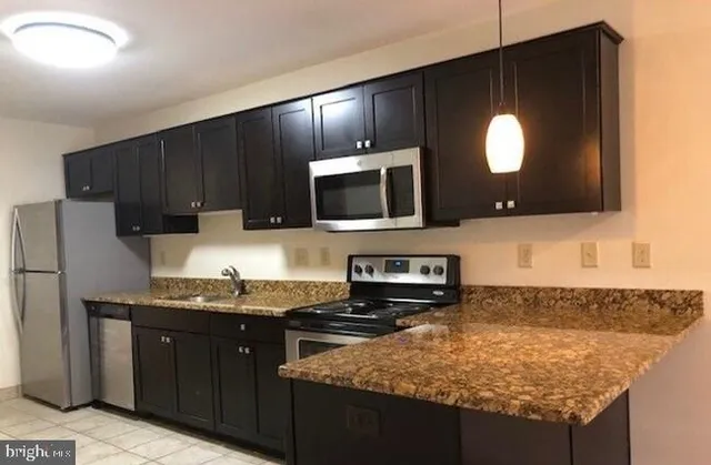 a kitchen with stainless steel appliances granite countertop a sink stove and microwave