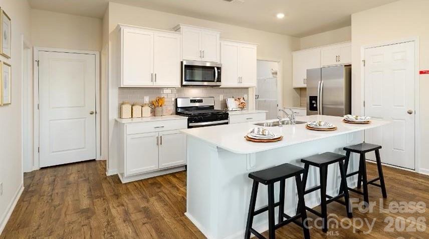 1720 Vanderlyn Street Monroe, NC 28112 - Photo 6 of 33 a kitchen with stainless steel appliances a white table and chairs