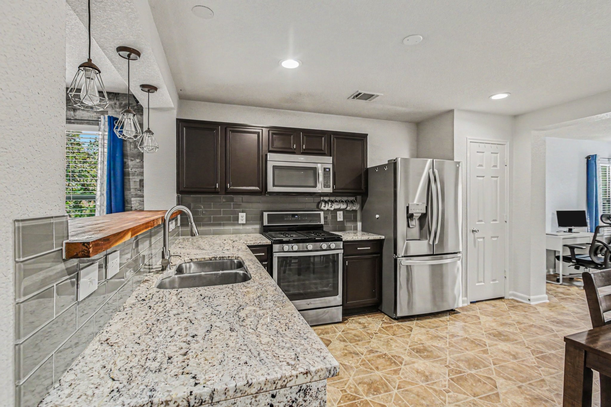 2903 Swift Brook Glen Way Spring, TX 77389 - Photo 9 of 30 Impressive kitchen showcases fabulous granite countertops, dark cabinets, and stainless steel appliances.