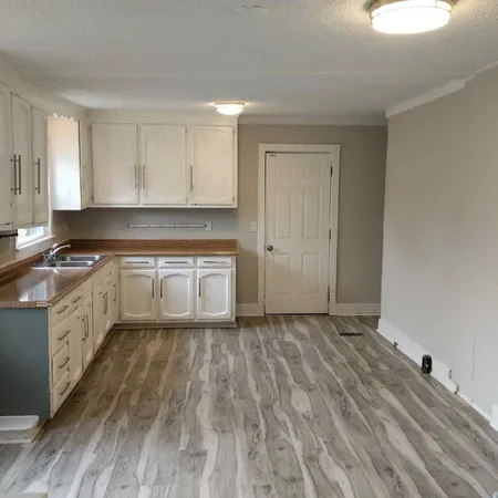 a kitchen with granite countertop a sink cabinets and stainless steel appliances
