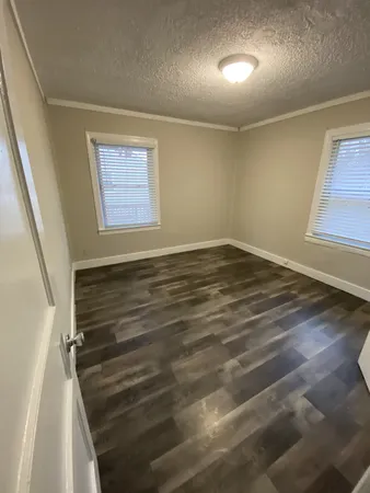 an empty room with wooden floor and closet