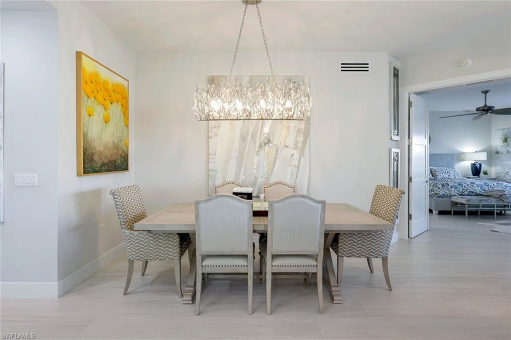 415 Sea Grove Lane, Unit 102 Naples, FL 34110 - Photo 12 of 36 a view of a dining room with furniture and chandelier