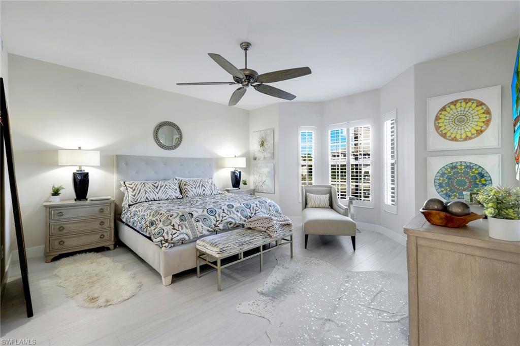 415 Sea Grove Lane, Unit 102 Naples, FL 34110 - Photo 13 of 36 a bedroom with a bed and ceiling fan