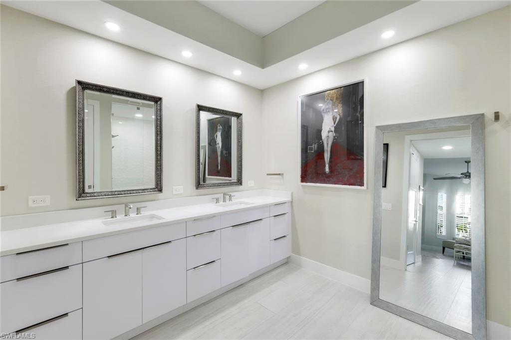 415 Sea Grove Lane, Unit 102 Naples, FL 34110 - Photo 14 of 36 a bathroom with a double vanity sink and a mirror