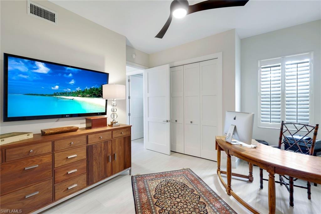 415 Sea Grove Lane, Unit 102 Naples, FL 34110 - Photo 16 of 36 a living room with furniture and a flat screen tv