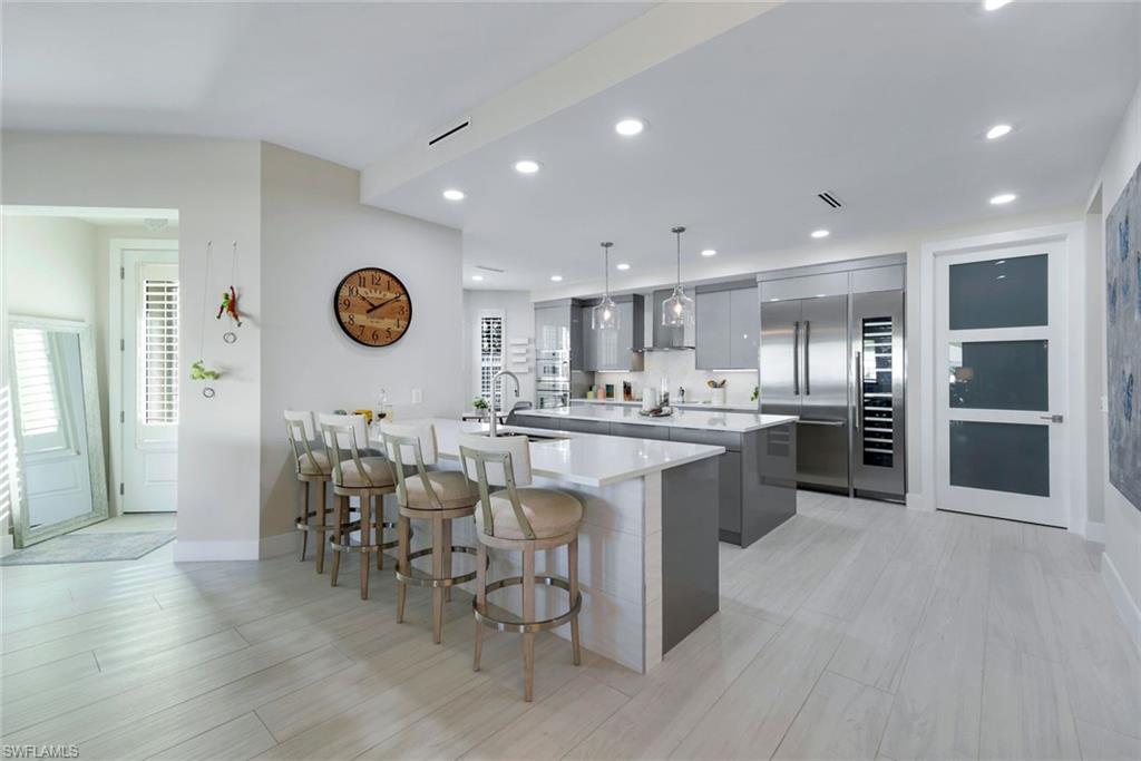 415 Sea Grove Lane, Unit 102 Naples, FL 34110 - Photo 6 of 36 a kitchen with a sink cabinets and wooden floor