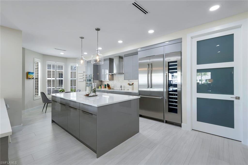 415 Sea Grove Lane, Unit 102 Naples, FL 34110 - Photo 7 of 36 a large kitchen with kitchen island a sink stainless steel appliances and cabinets