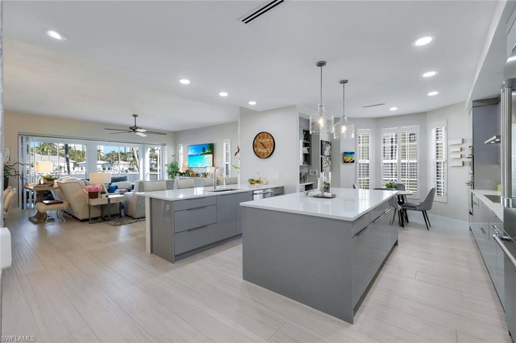 415 Sea Grove Lane, Unit 102 Naples, FL 34110 - Photo 8 of 36 a large white kitchen with a large island in the center