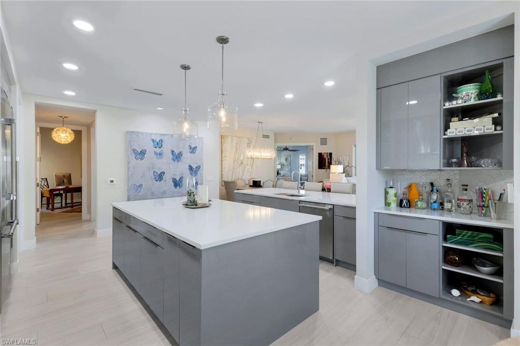 415 Sea Grove Lane, Unit 102 Naples, FL 34110 - Photo 10 of 36 a kitchen with kitchen island a sink a center island and stainless steel appliances